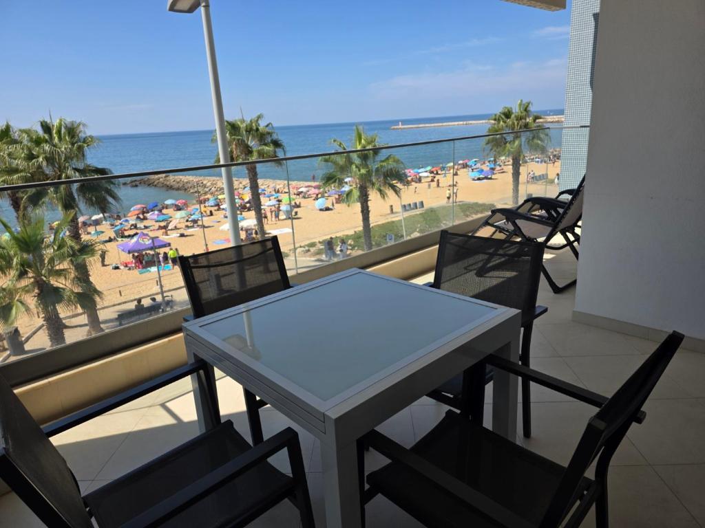 a table and chairs on a balcony with a view of the beach at Brisa do Mar - 2BR Sea Front Luxury Apartment in Quarteira