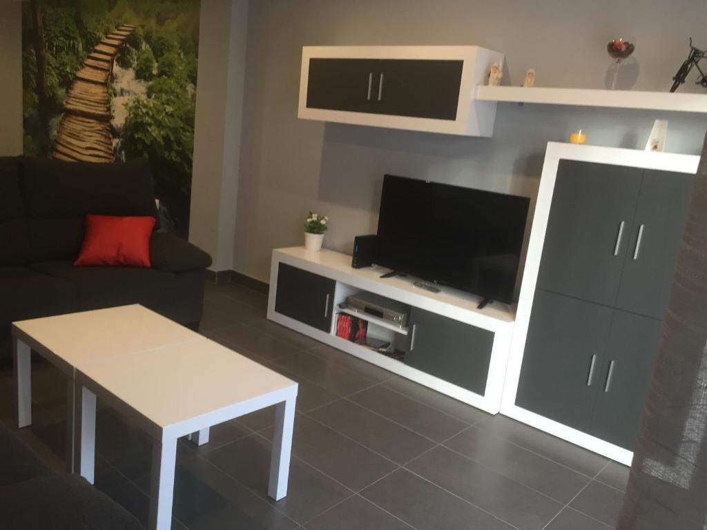 sala de estar con TV, sofá y mesa en Apartamento De Lujo En Orihuela Ciudad, en Orihuela