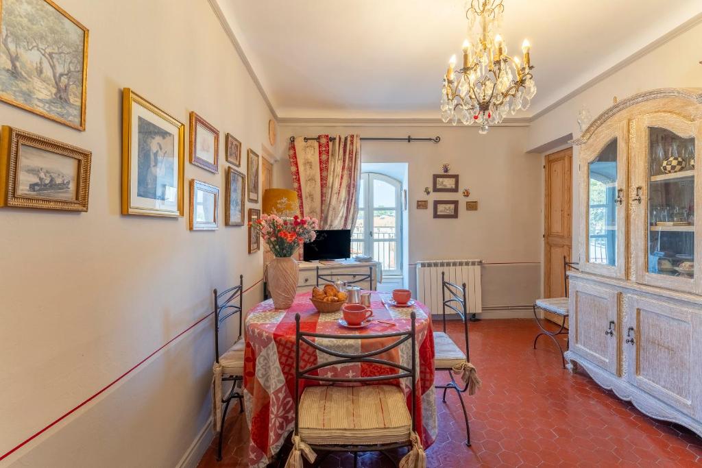 een eetkamer met een tafel en een kroonluchter bij Appart face au Palais des Papes in Avignon