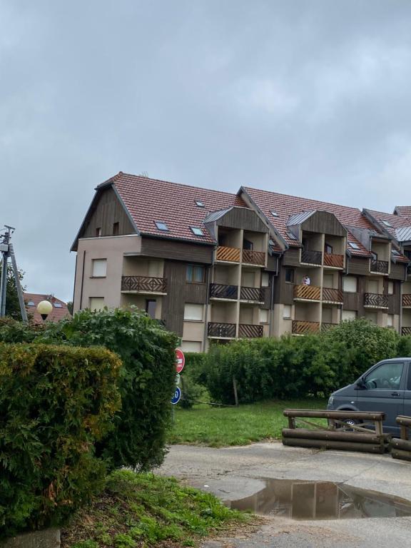 a large building with a car parked in front of it at Un coin de paradis au pied des pistes avec balcon in Métabief