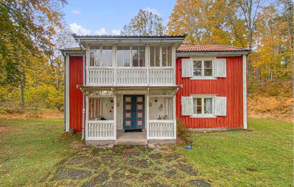a red and white house with a blue door at 4 Bedroom Nice Home In Nybro in Pukeberg