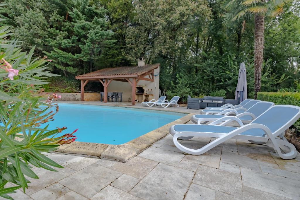 a swimming pool with lounge chairs and a gazebo at Les Combes De Rieux in Sarlat-la-Canéda