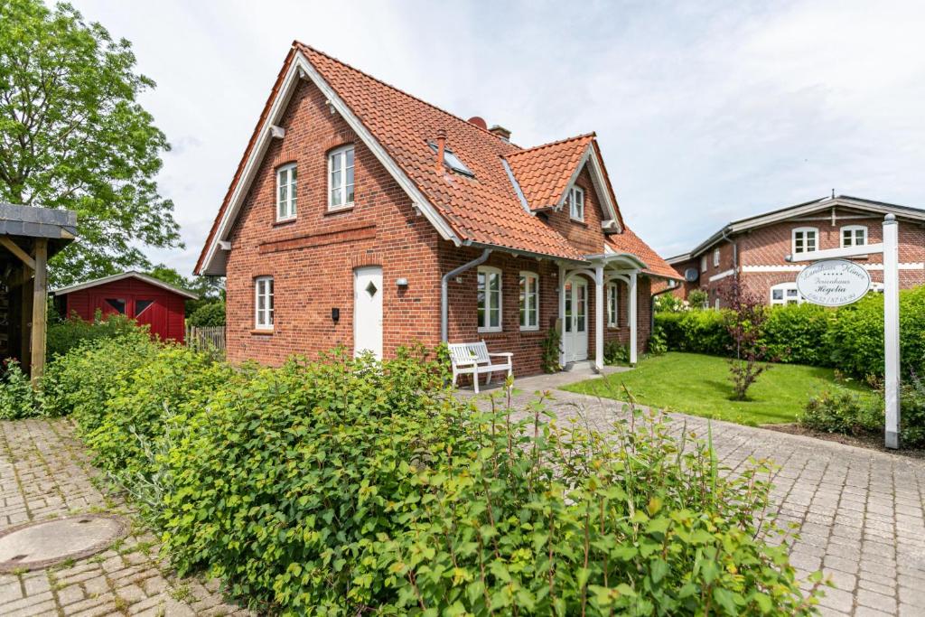 an old brick house with a white door at Landhaus Högelia Flensbúrger Förde in Quern