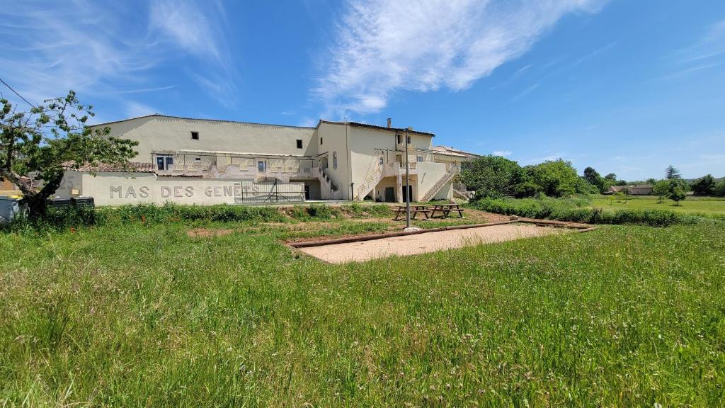 a building in the middle of a field of grass at Mas Des Genêts in Laurac-en-Vivarais