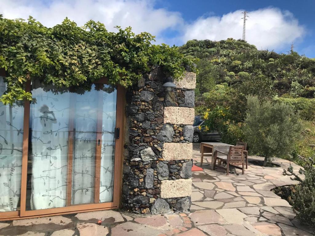 a stone wall with a window and a table at Casa La Tedera in El Pinar del Hierro