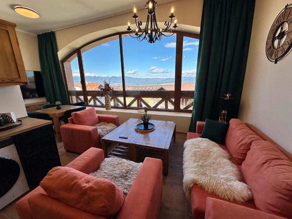 a living room with a couch and chairs and a large window at Murphys Lodge panorama apartment in Bansko
