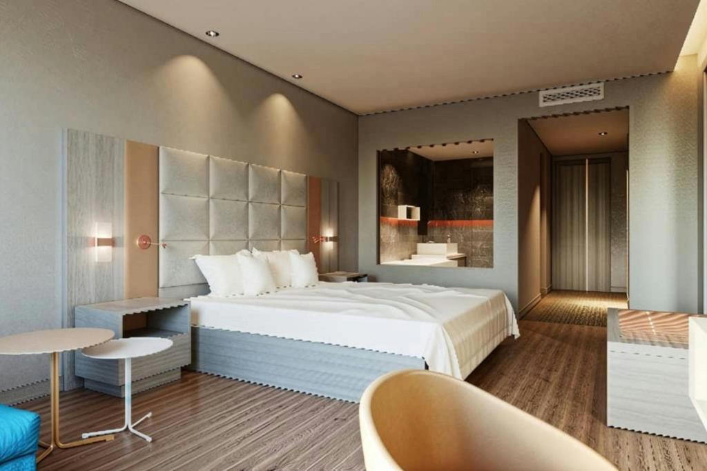 ein Schlafzimmer mit einem großen Bett, einem Tisch und Stühlen in der Unterkunft Four Points by Sheraton Accra Kotoka Airport in Accra