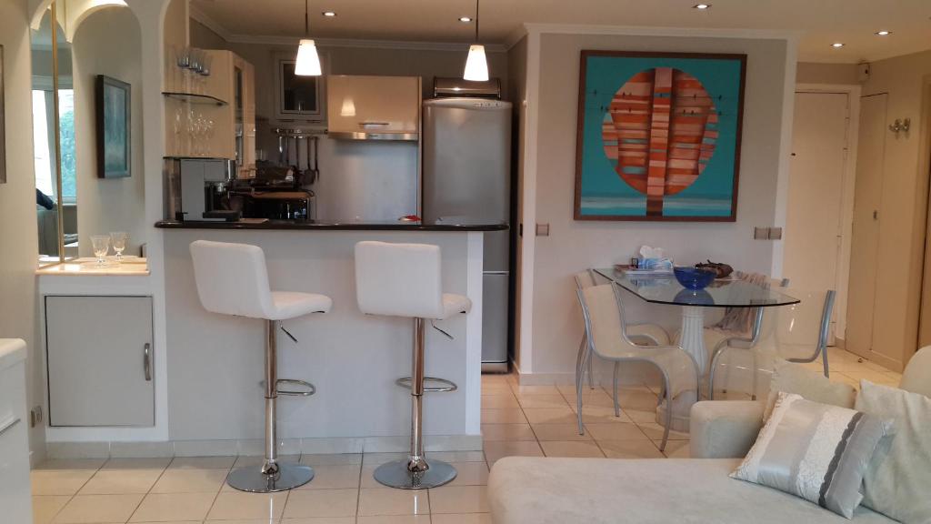 a kitchen and living room with a table and chairs at Elegant Apart in City Centre of Cannes in Cannes