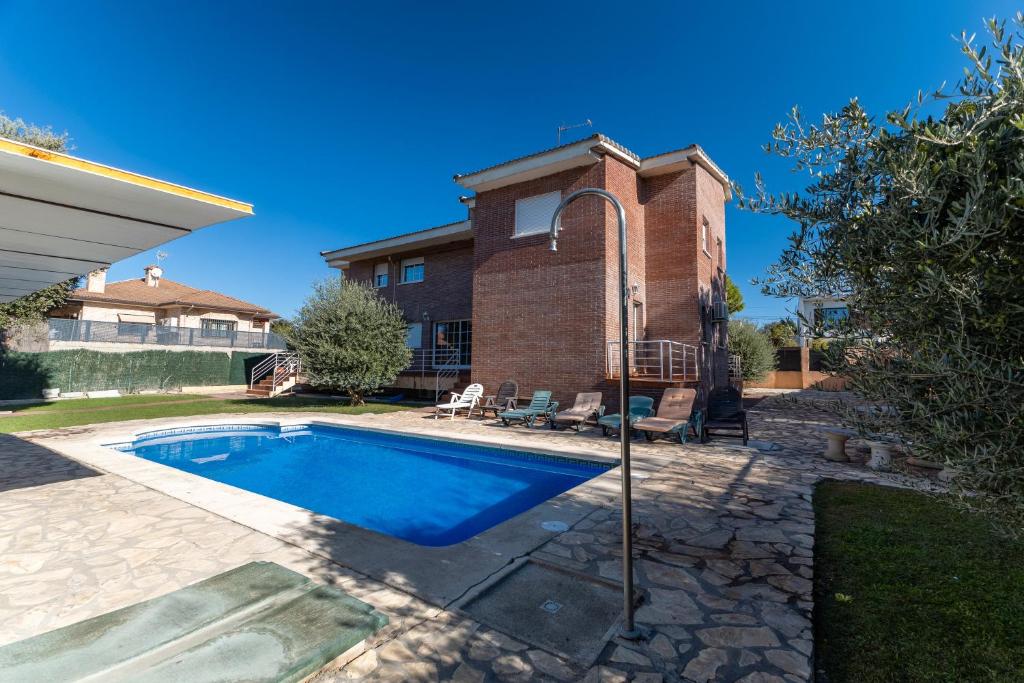 a swimming pool in front of a house at Villa Pilara - Brunete in Brunete