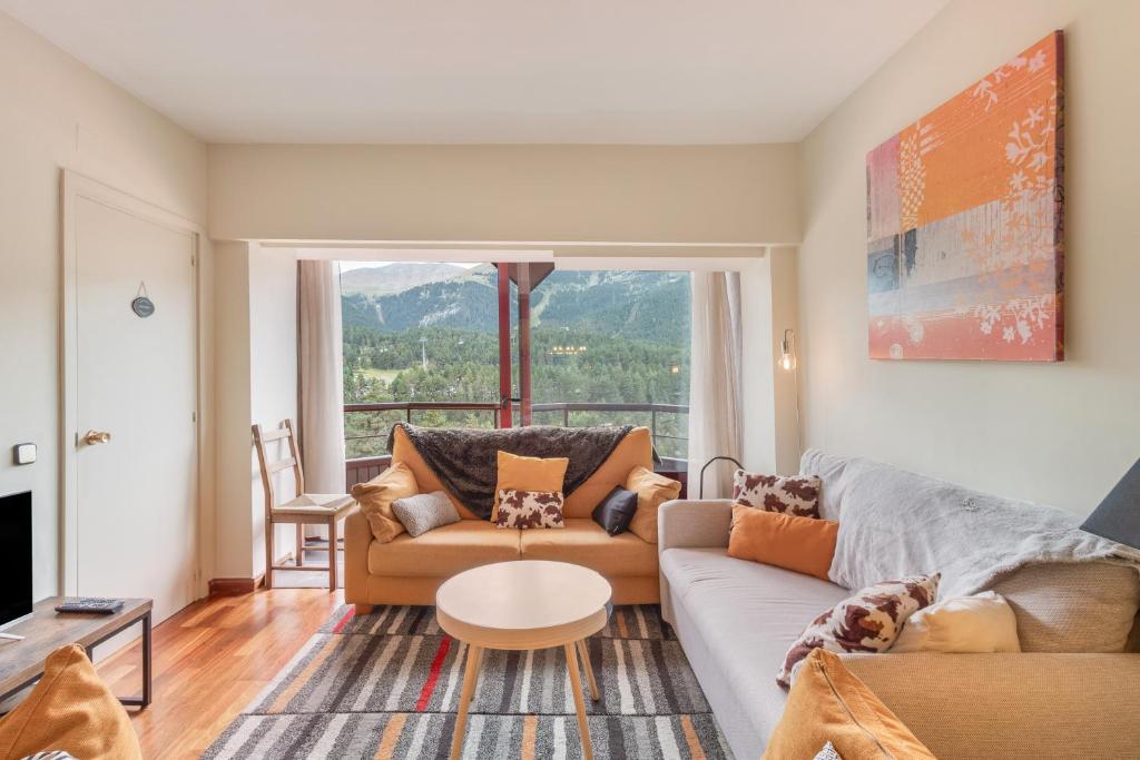 een woonkamer met een bank en een tafel bij Apto Ideal En La Molina in Alp