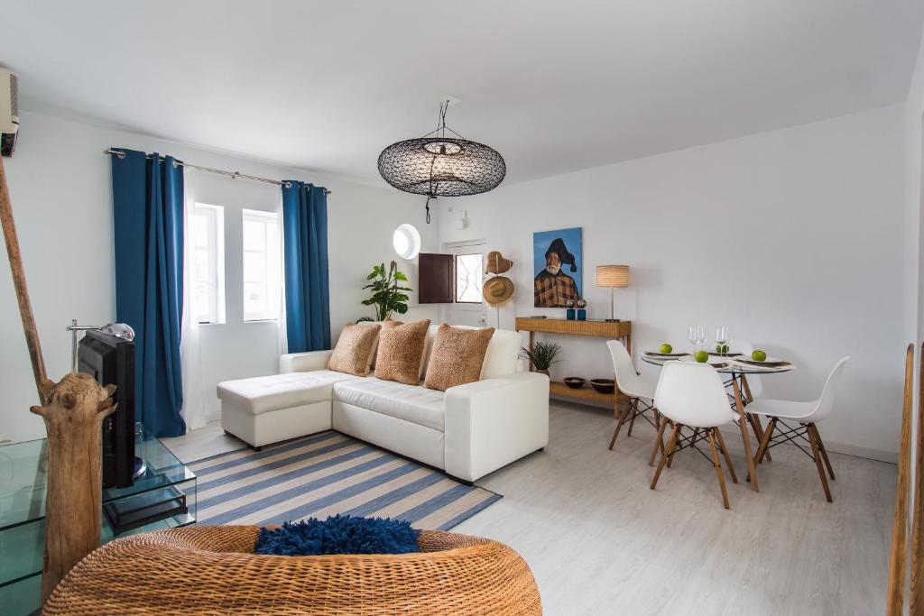 a living room with a white couch and a table at Beach And Mountain Apartment in Sesimbra