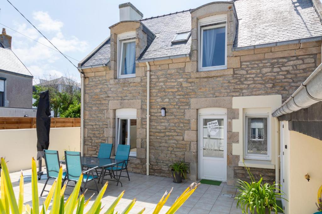 a patio with a table and chairs in front of a building at La pince de crabe à 300m de la mer in Le Guilvinec