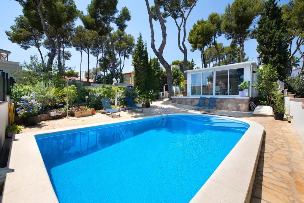 una piscina in un cortile con una casa di Ethel a Castelldefels