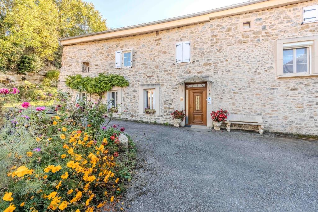 a stone house with a bench in front of it at Gite du moulin - Ariège in Carla-de-Roquefort
