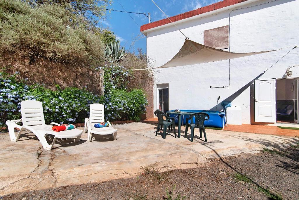 a patio with four chairs and a table and a ping at Vivienda V Torres 4 in Vega de San Mateo
