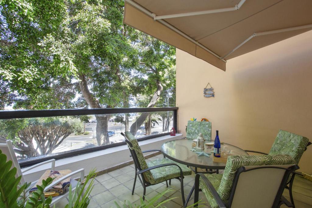 San AndrésにあるApartment By The Seaのバルコニー(テーブル、椅子付)、大きな窓が備わります。