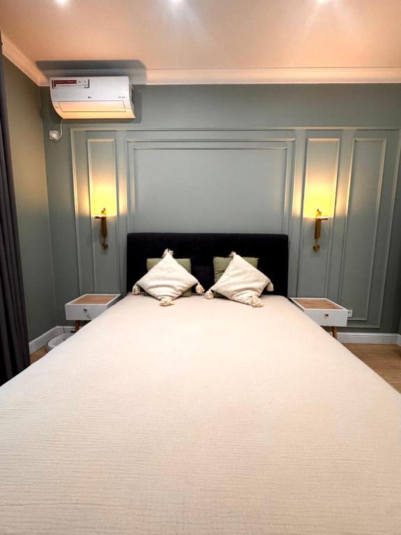 a large bed with two pillows on top of it at Central Park Apart in Karagandy