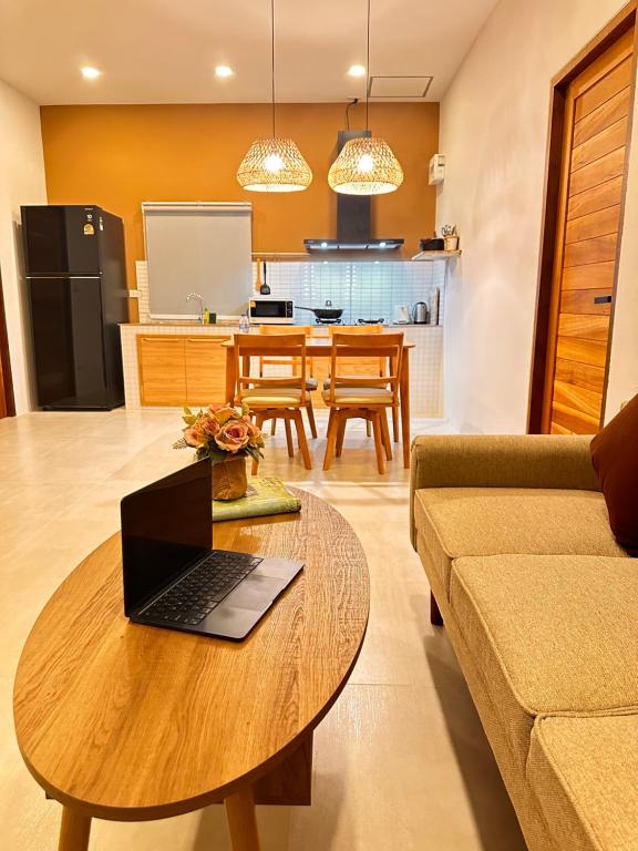 een woonkamer met een tafel met daarop een laptop bij Baan Suan Poolsap - Haad Rin Beach in Haad Rin