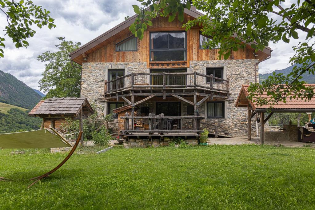 une grande maison avec un balcon au-dessus d'une cour dans l'établissement Chalet La Sentinelle, à Bellecombe