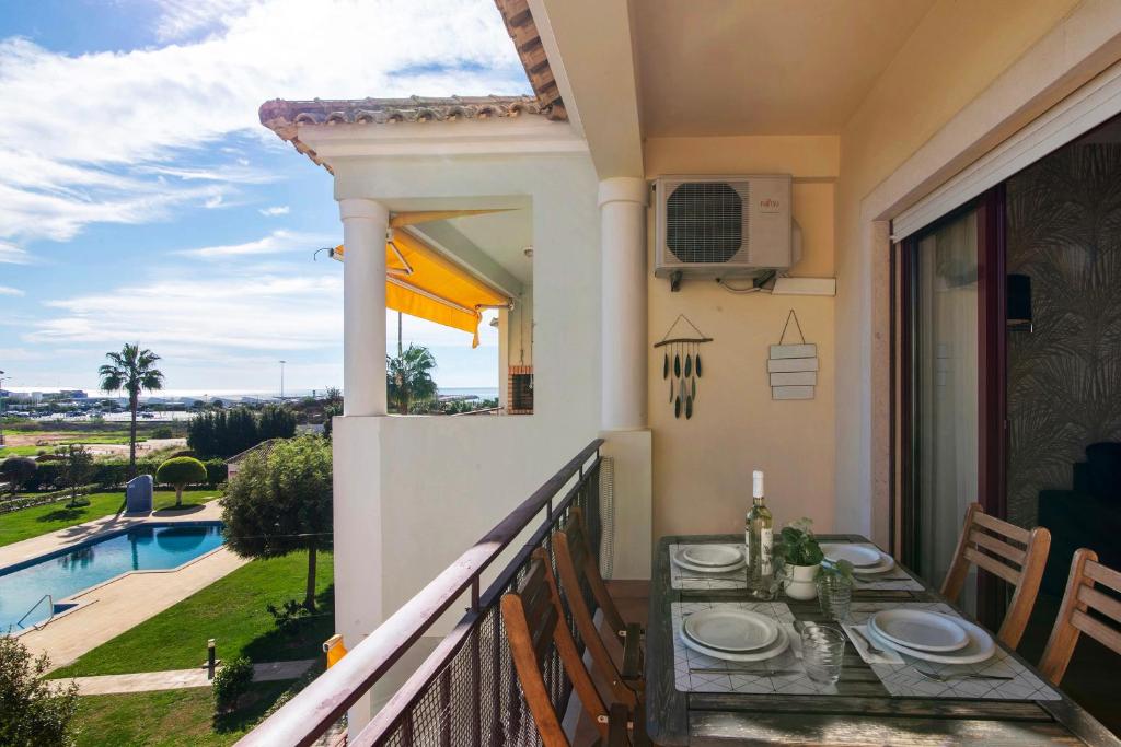 a balcony with a table and a view of a pool at Cosy Apartment With Pool 2 in Vilamoura