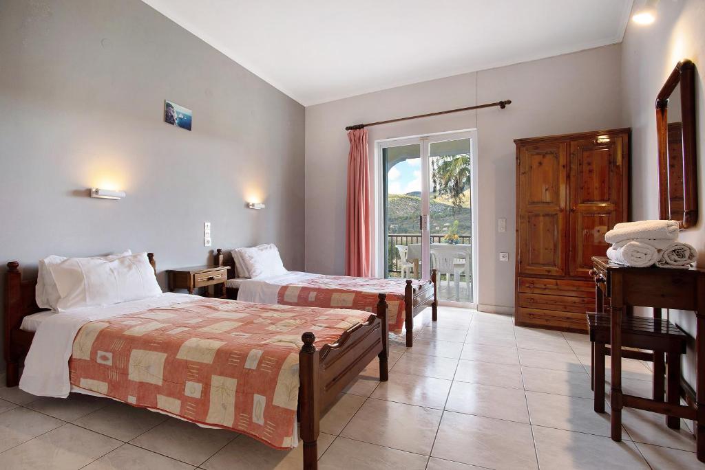 a hotel room with two beds and a balcony at Dolphin Apartment 4 in Keri