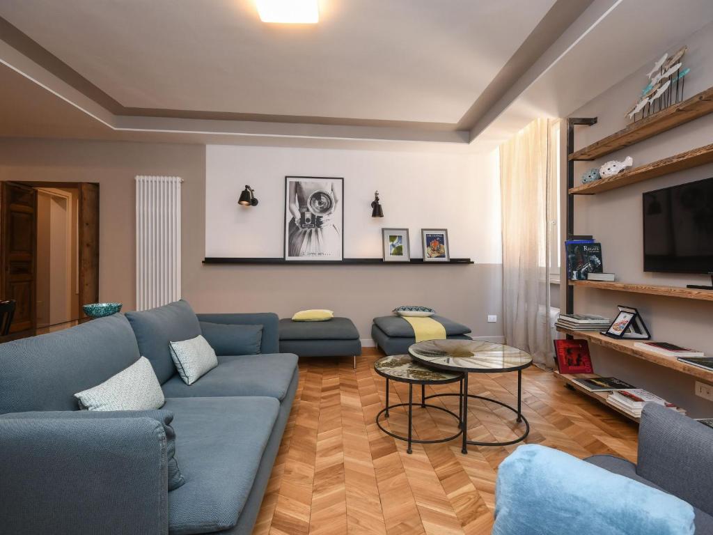 a living room with a blue couch and a table at Luxury modern apartment by the lake in Salò