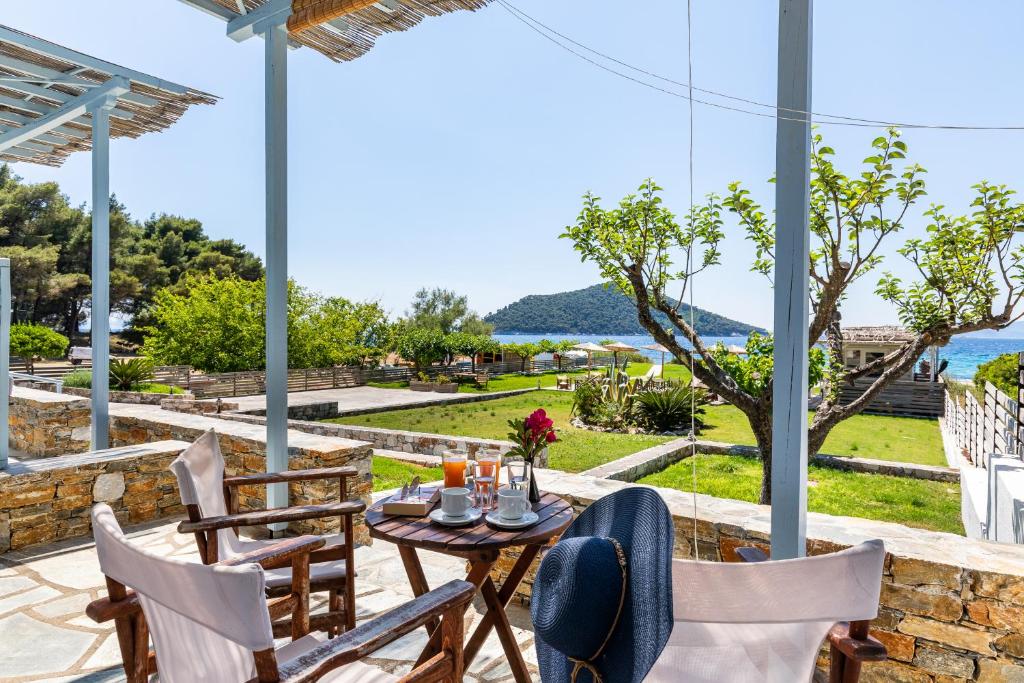 a patio with a table and chairs and a view of the water at Milia Beach Apartments in Paralia Milia