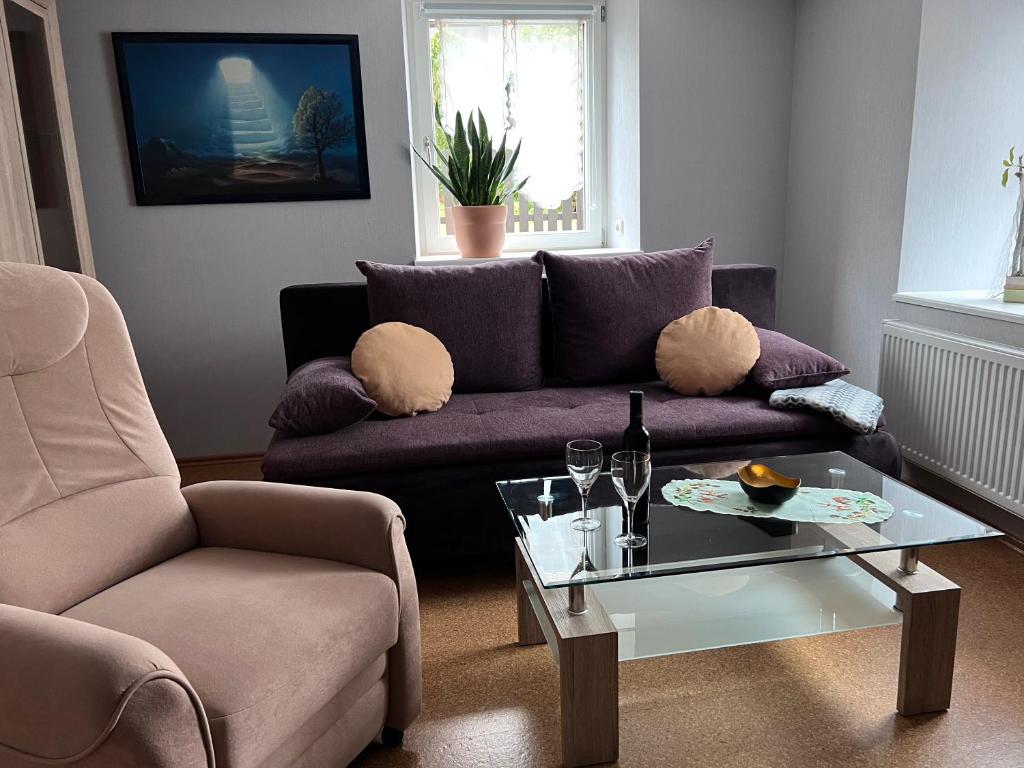 WehrにあるFerienwohnung Schmidtのリビングルーム(紫色のソファ、ガラスのテーブル付)