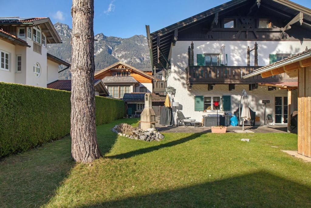 une cour avec un arbre et une maison dans l'établissement Alpen Lodge, à Garmisch-Partenkirchen