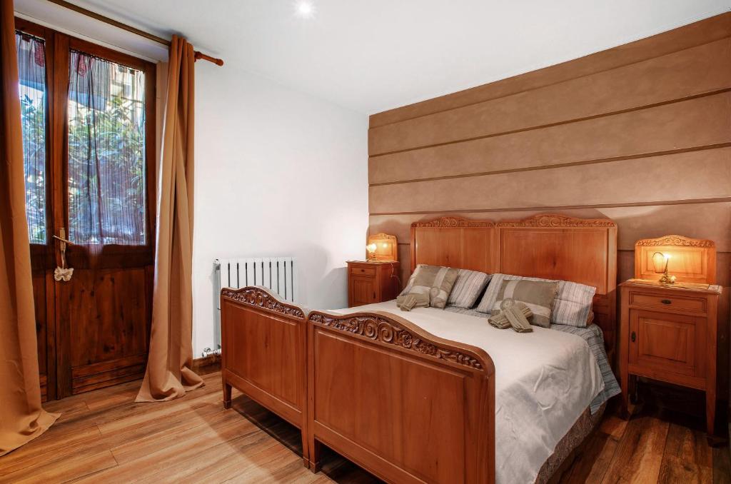 une chambre avec un grand lit en bois et une fenêtre dans l'établissement Appartamento Buthier Aosta, à Aoste