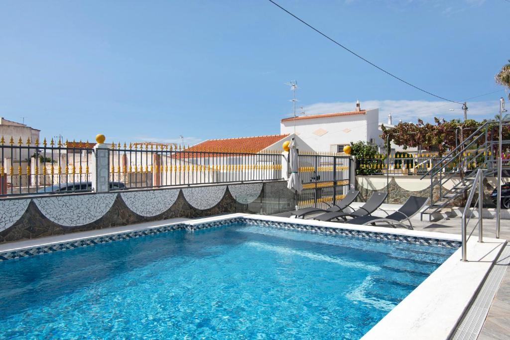 a swimming pool with two chairs and a fence at Andar Paraíso in Altura