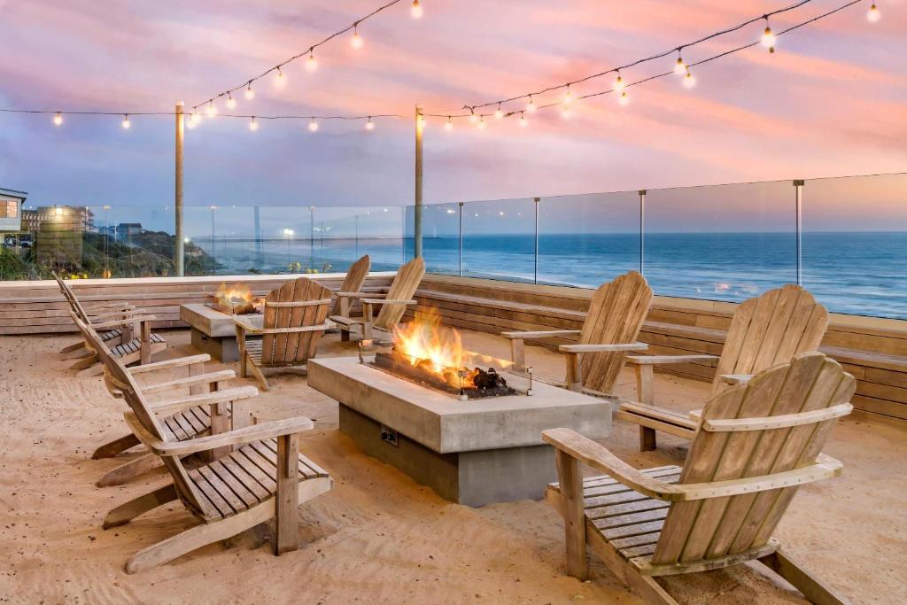 a group of chairs around a fire pit on the beach at Elizabeth Oceanfront Suites, an Ascend Collection Hotel in Newport