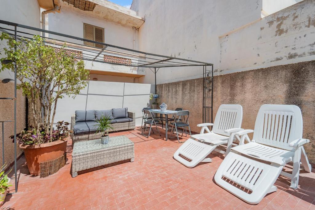 a patio with two white chairs and a table at Casa Vacanza- Sa Nue in Calasetta