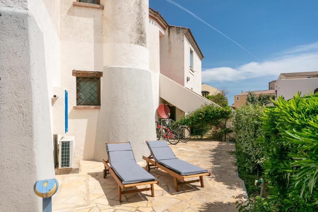 2 chaises assises sur une terrasse à côté d'un bâtiment dans l'établissement Appartamento in centro Sole e Mare, à Porto San Paolo