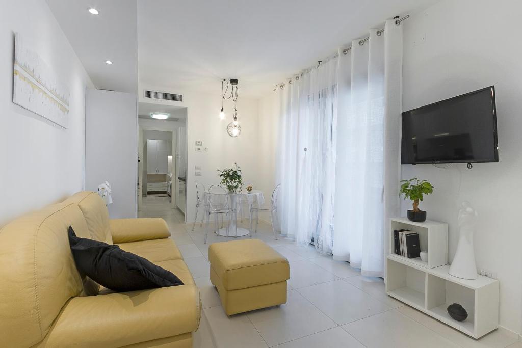 a living room with a yellow couch and a tv at Ricky's Luxury Apartment in Misano Adriatico