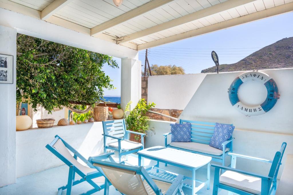 a patio with blue chairs and a table at Beachfront Lampis Dolphin 2 in Skala