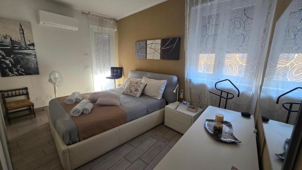 瓦雷泽VARESE PRIME - Feel at home, right in the heart of Varese - Stylish and large Apartment, Air Conditioning, 2 Baths, 2 Parking, City Centre, Villa Esengrini Montalbano的一间带床和桌子的小卧室
