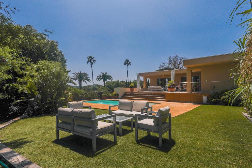 une maison avec deux chaises et une table dans la cour dans l'établissement La Villa Capitane, à Grimaud