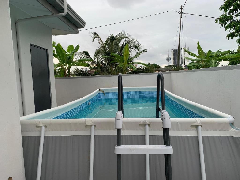 a swimming pool on the side of a fence at RUMAH BENDANG ALOQSETAQ -Private PooL - Panoramic view of rice fields and Alor Setar Tower in Alor Setar