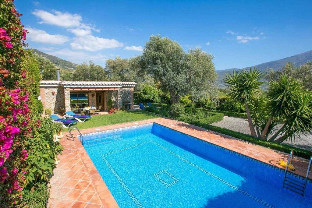 a swimming pool in front of a house at Casa Buganvilla by Vintage Travel in Órgiva