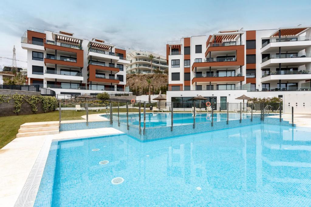 a swimming pool in front of a apartment building at Holiday apartment Middle Views in Fuengirola