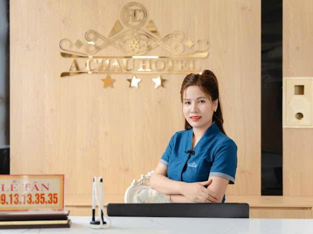 Eine Frau, die an einem Tisch mit gekreuzten Armen sitzt. in der Unterkunft Khách Sạn Á Châu in Trại Khao