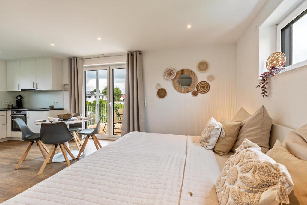 a bedroom with a large bed and a kitchen at Fewo Parkside S4 - 8Min Legoland in Günzburg