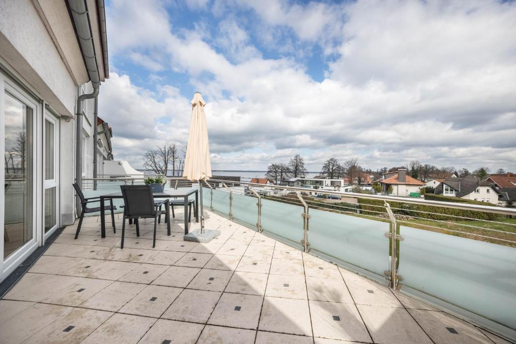 a balcony with a table and chairs and an umbrella at Studio in Steinhude