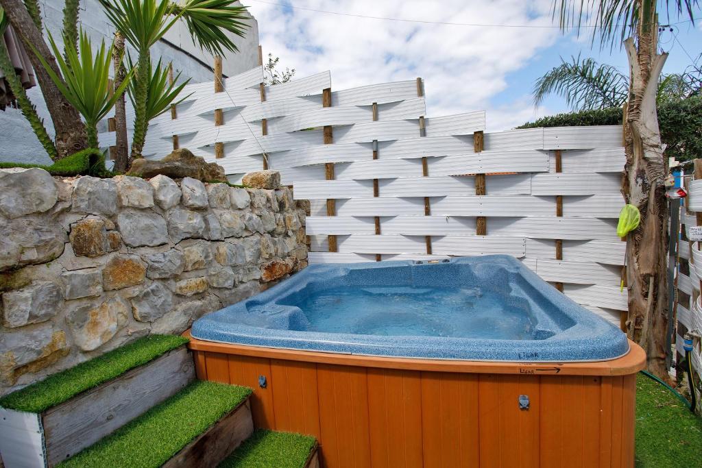 a hot tub in front of a white fence at Moradia Dos Castelos Azul in Ourém