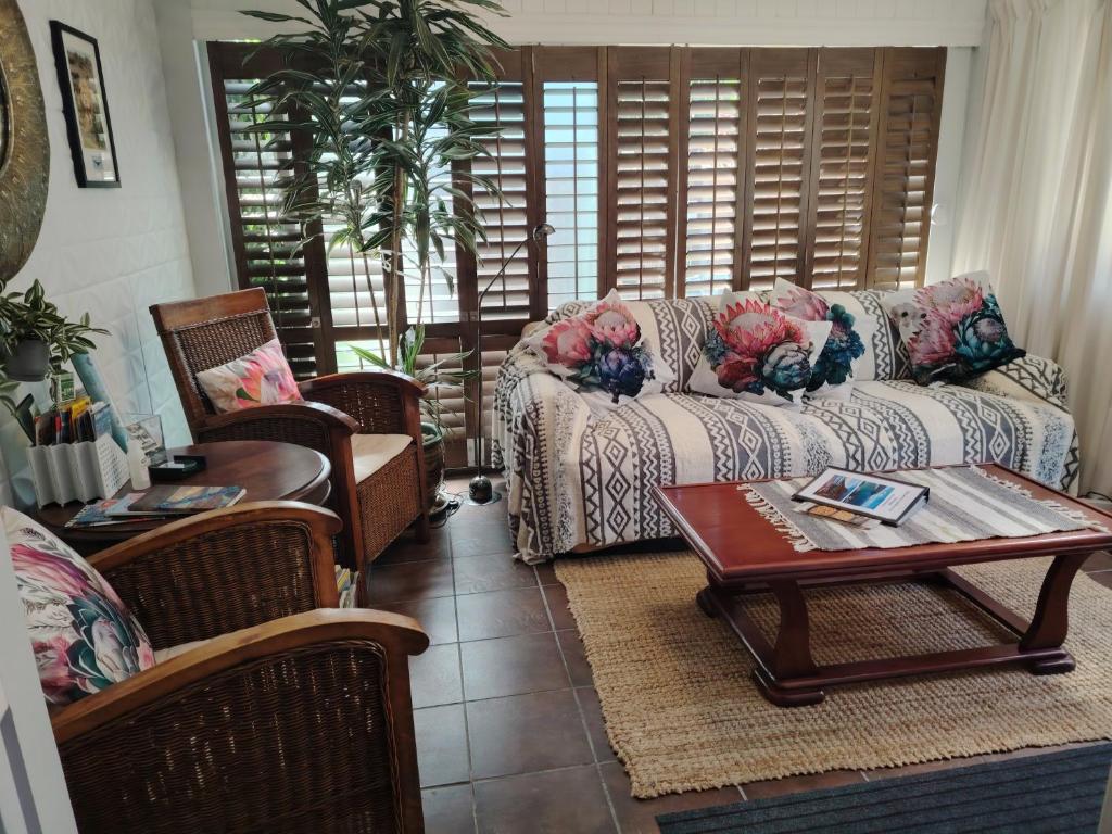 a living room with a couch and chairs and a table at Twelveon1st in Cape Town