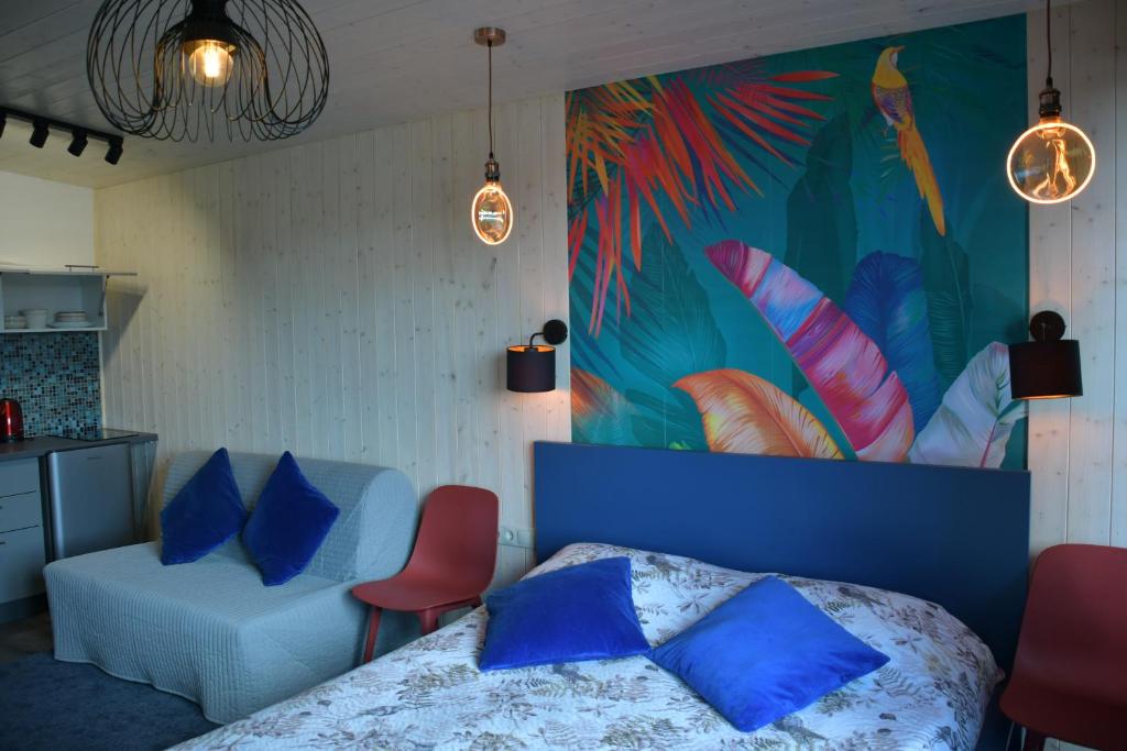 a bedroom with a blue bed and a colorful wall at Central Riverside Apartments in Jēkabpils