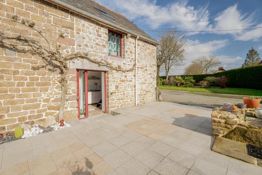 Elle offre une vue sur un bâtiment en briques doté d'une terrasse. dans l'établissement Les mesliers, à Sens-de-Bretagne