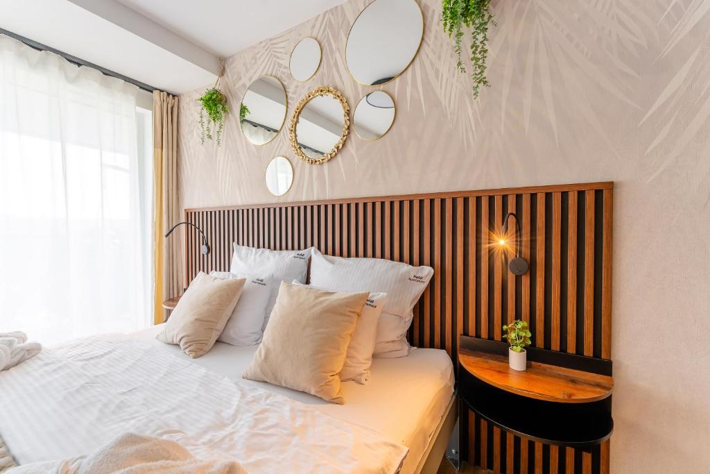 Un dormitorio con una cama con sábanas y almohadas blancas. en Heidi-Apartament, en Kołobrzeg