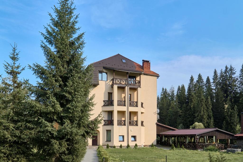 a large building with a tree in front of it at Aratta in Pilipets